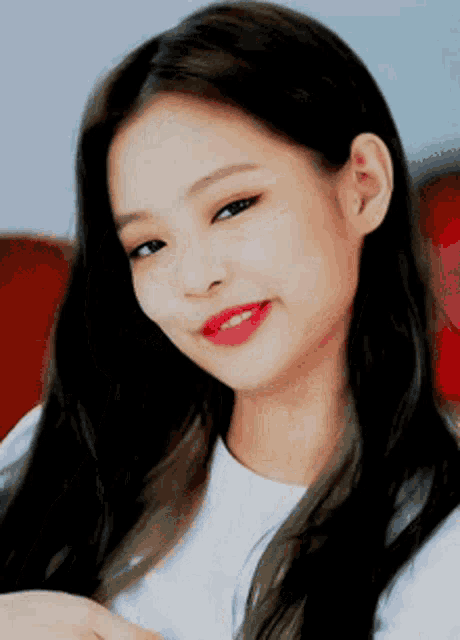 a close up of a woman with long hair wearing a white shirt and red lipstick