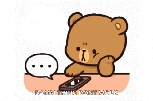 a teddy bear is sitting at a table using a cell phone and a speech bubble .