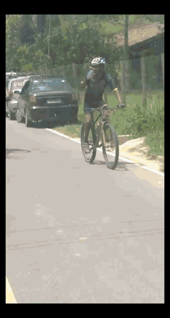 a man wearing a helmet rides a bike down a street