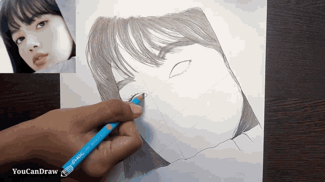 a person is drawing a woman 's face with a pen that says youcandraw on it