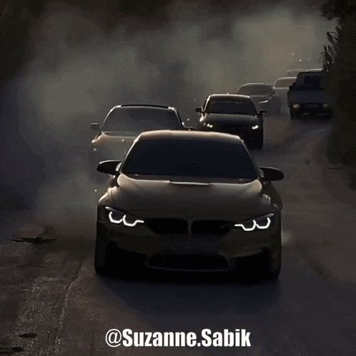 a group of cars driving down a road with smoke coming out of their tires