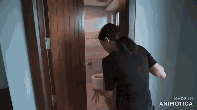 a woman in a black shirt is opening a door to a bathroom made by animatica