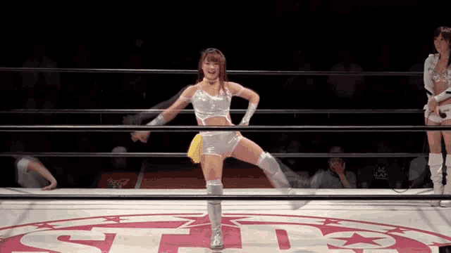 a woman in a wrestling ring with the letter t on the floor