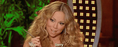a woman with long blonde hair is sitting in front of a green screen and says `` sorry '' .