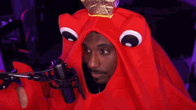 a man in a red octopus costume is singing into a microphone with the words " you are still so " written below him