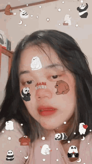 a girl with bare bears stickers on her face looks at the camera
