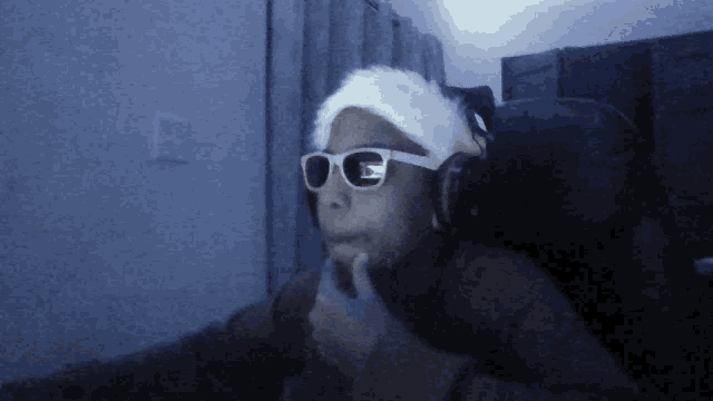 a person wearing sunglasses and a white headband with the letter g on them