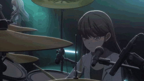 a girl is playing a drum set and singing into a microphone