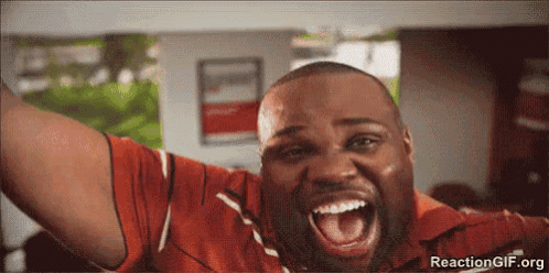 a man in a red shirt is screaming with his mouth open and his arms in the air .