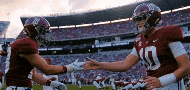 two football players shaking hands in a stadium with one wearing a number 10 jersey