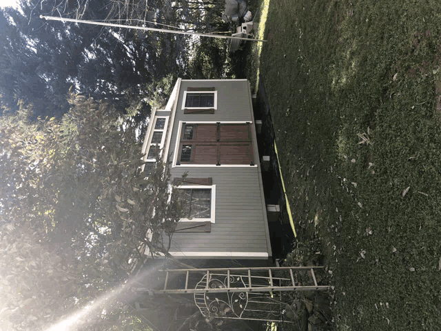 a small house is sitting in the middle of a grassy yard
