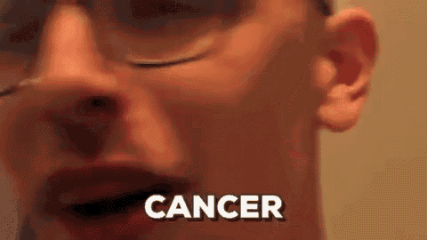 a close up of a man 's face with the word cancer written in white letters .