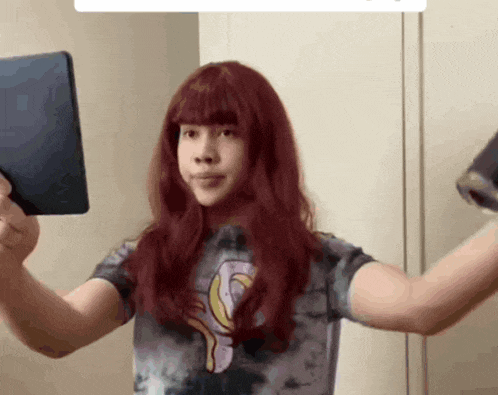 a person with red hair is holding a tablet and a can of soda