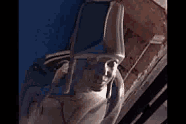 a statue of a man with a hat on his head is sitting in a chair .