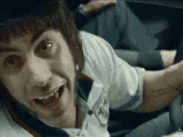a man with a tattoo on his arm is smiling with his mouth wide open .
