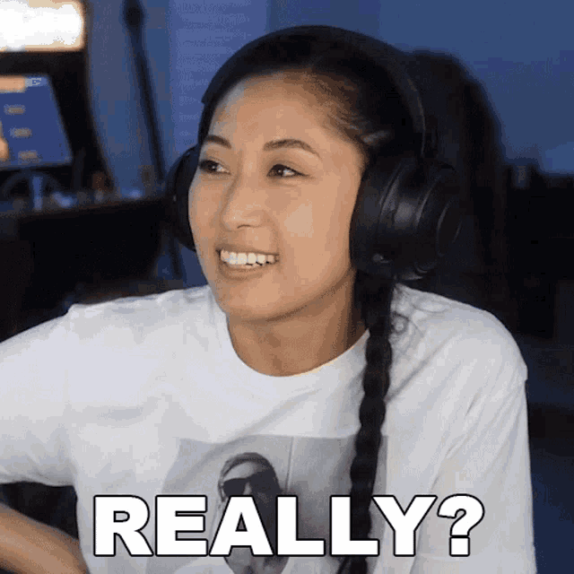 a woman wearing headphones and a white shirt says " really "