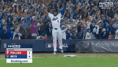 a mets player jumps in the air with his arms up