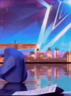 a blue origami bird is sitting on a table in front of a blue background .