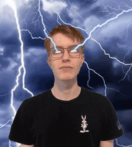 a man wearing glasses and a black shirt with a bunny on it stands in front of lightning