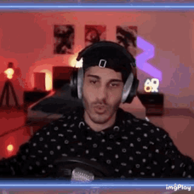 a man wearing headphones is sitting in front of a microphone .