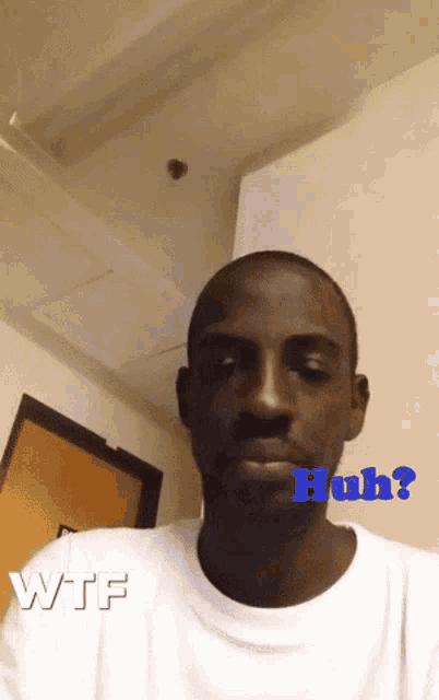 a man in a white shirt has the word huh written on his face