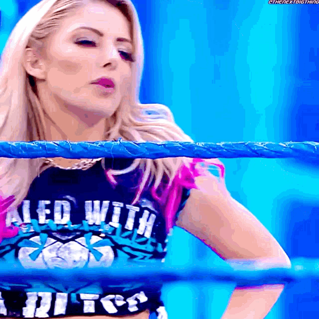 a woman in a wrestling ring wearing a shirt that says " led with "