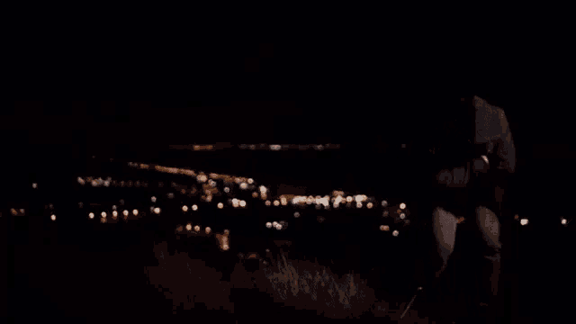 a man in a hooded jacket is looking at the camera at night .