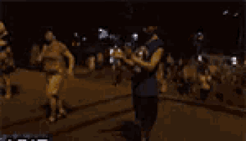 a blurry picture of a man and a woman walking down the street at night .