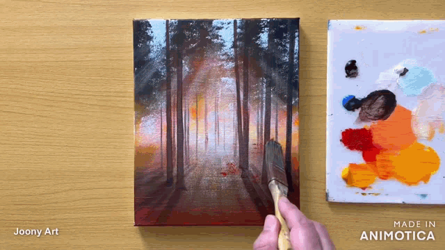 a painting of a forest is being painted on a canvas by joony art