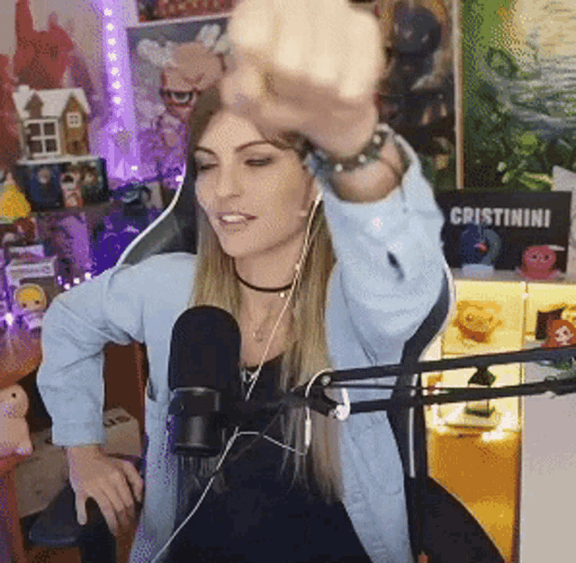 a woman in front of a microphone with a sign that says cristinini on it