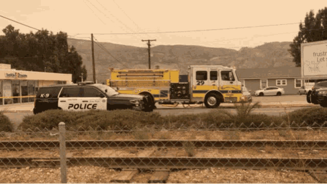 a police car is parked next to a fire truck number 29