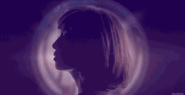 a silhouette of a woman 's face with purple hair against a purple background .