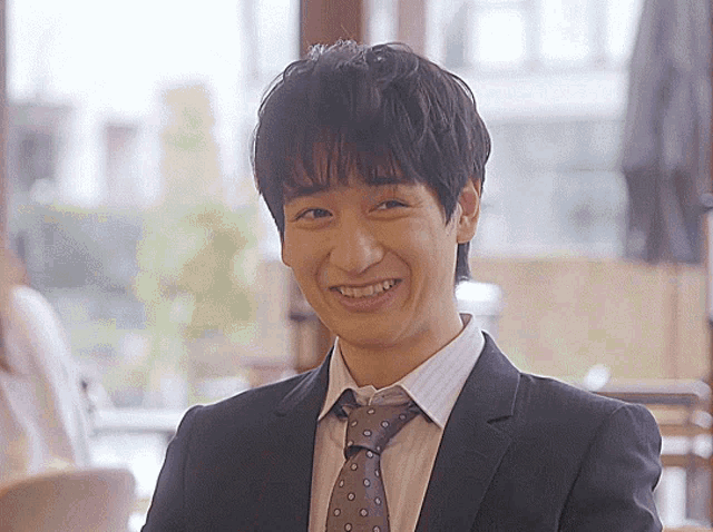 a man in a suit and tie is smiling