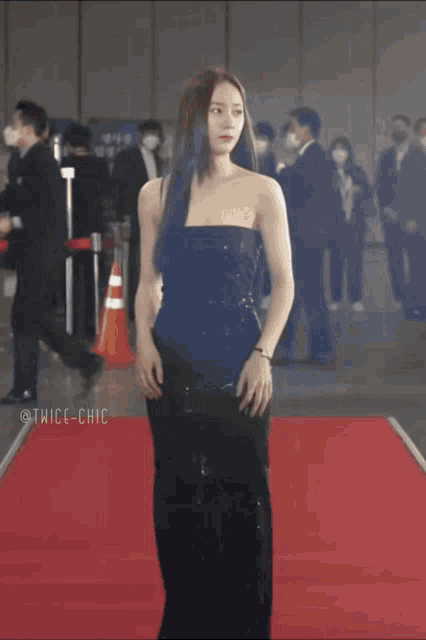a woman in a black strapless dress is on a red carpet