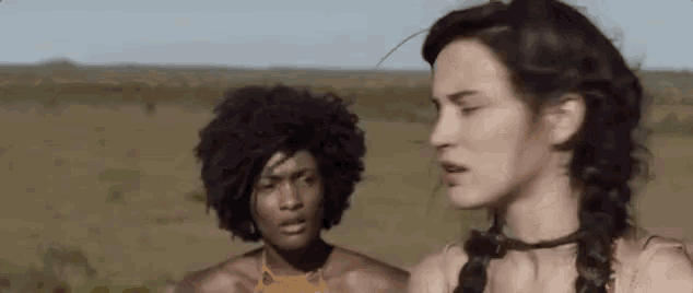 a man and a woman are standing in a field .