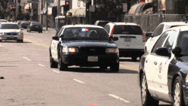 a black ford police car with a license plate that says jcrb126 is driving down a street