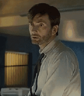 a man with a beard wearing a white shirt and tie is looking at the camera .