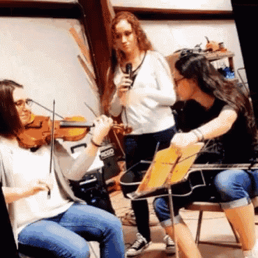 a woman playing a violin and another woman playing a guitar