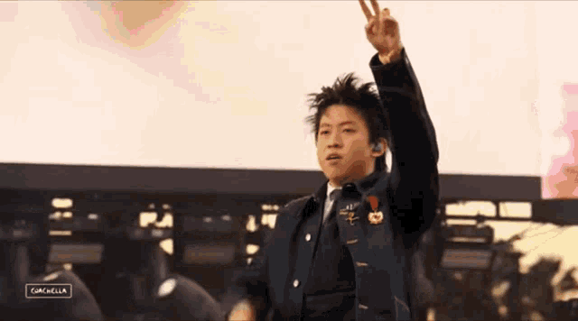 a young man giving a peace sign in front of a screen that says campbella