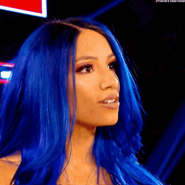 a close up of a woman with blue hair looking at the camera .