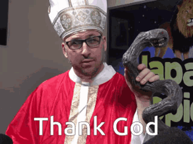 a man in a priest costume holds a snake with the words thank god written below him