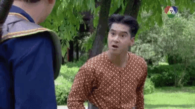 two men are standing next to each other in a park .