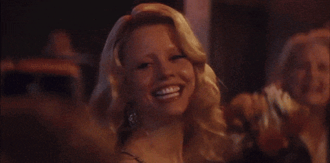 a woman in a white dress is smiling in front of a blurry background