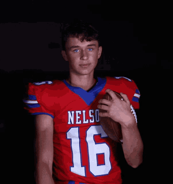 a football player with nelson 16 on his jersey holds a football