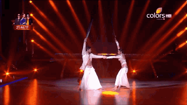 a man and a woman are dancing on a stage with a colors hd logo in the corner