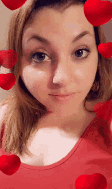a woman in a red tank top is surrounded by hearts