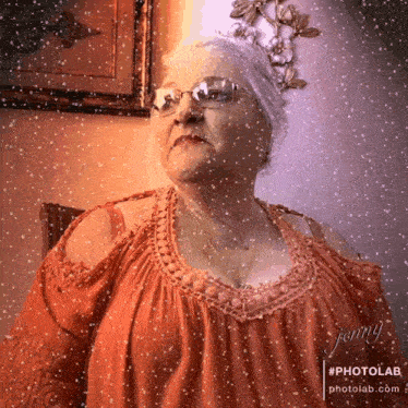 an elderly woman wearing glasses and a red top is standing in front of a window