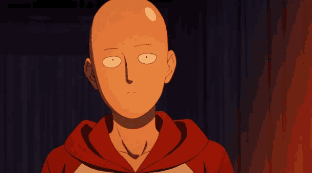a bald man in a red and white hoodie looks at the camera