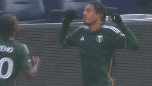 two soccer players are hugging each other and one has the number 30 on his jersey