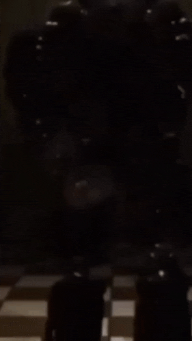 a person is standing on a checkered floor in the dark